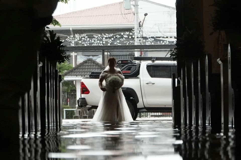 Wading in floodwater amid a deluge, a couple in the Philippines tie the knot