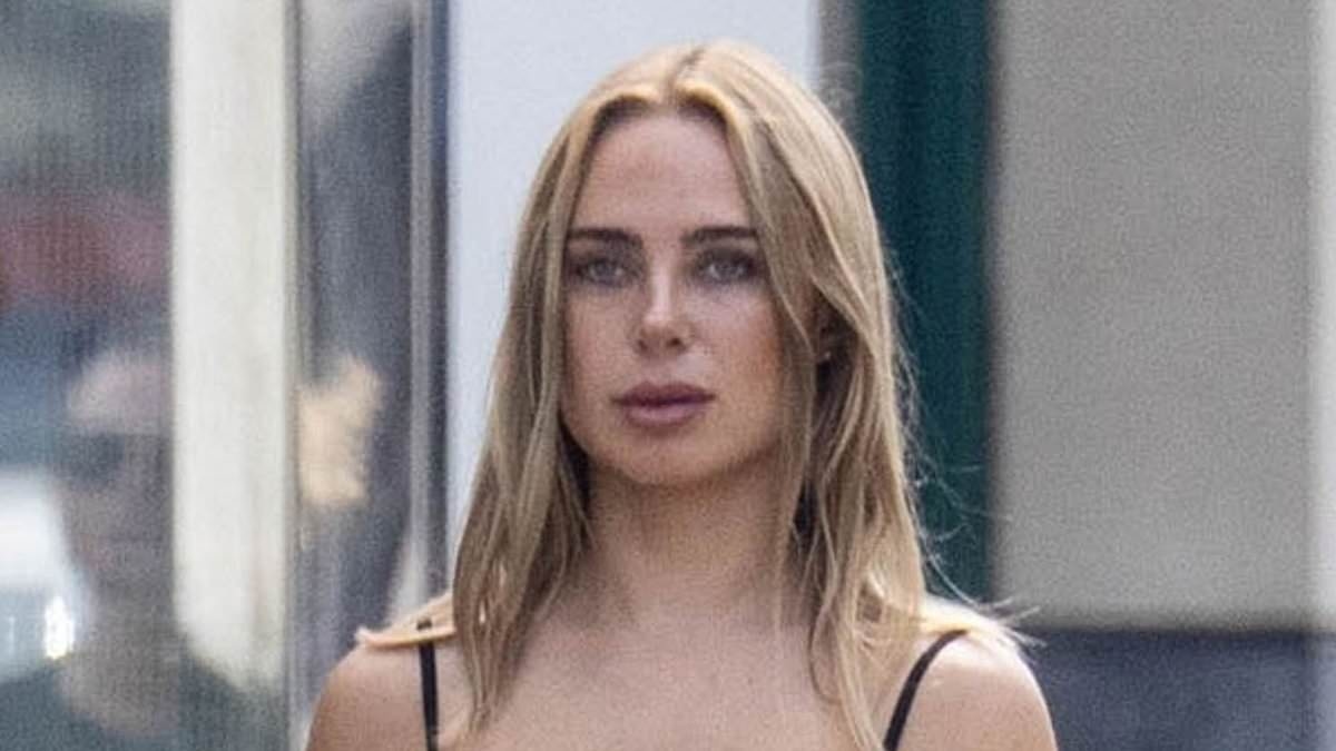 Kimberley Garner shows off her toned legs in a black mini dress as she walks her dog down Chelsea's King's Road