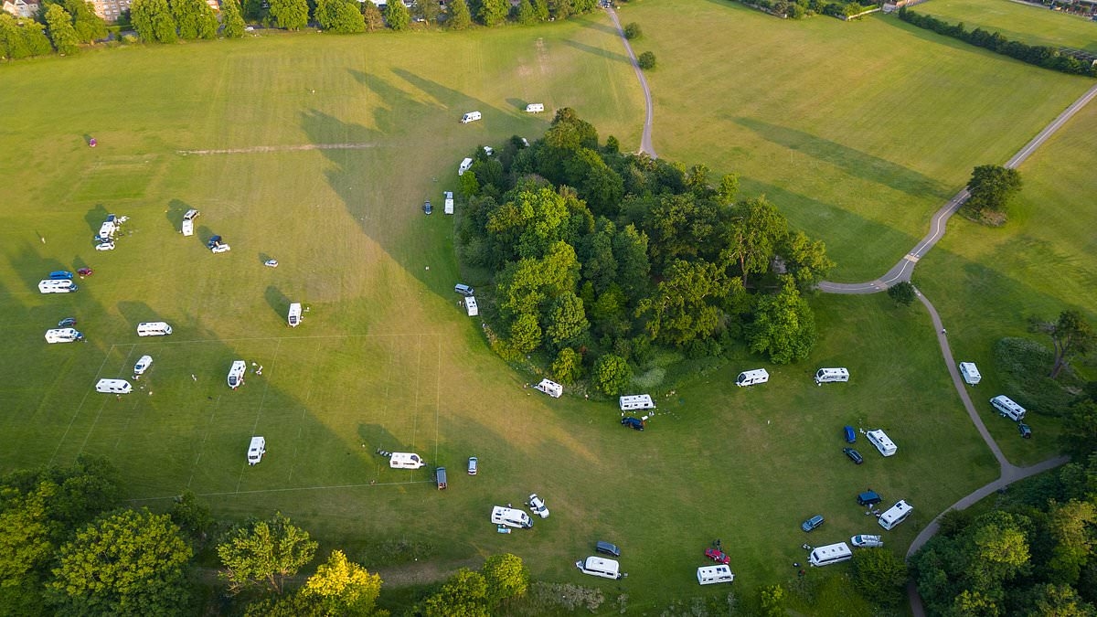 Travellers pitch up illegal encampment with up to 30 caravans on huge field next to Surrey's million pound homes