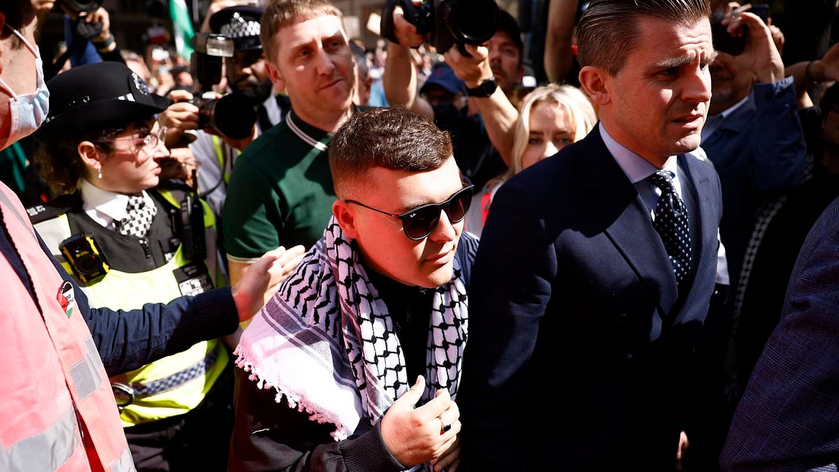 Crowds of Kneecap fans waving Palestinian flags mob court as rapper Mo Chara is bailed after being charged with terrorism offence 'for displaying Hezbollah flag'
