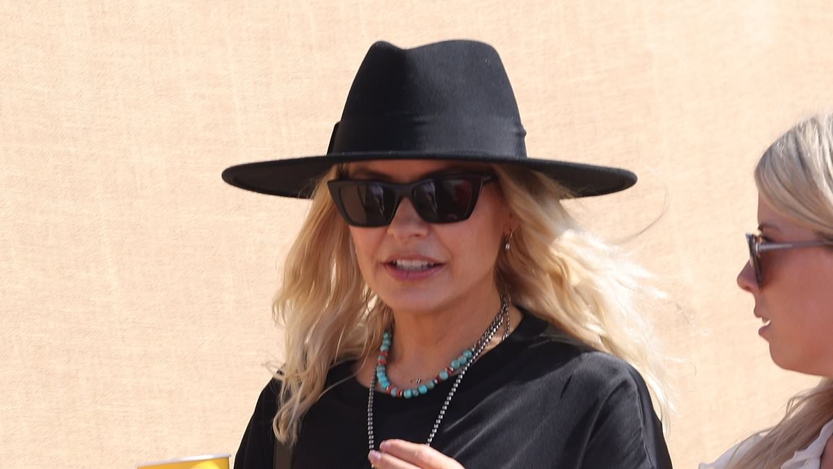 Holly Willoughby oozes festival chic in a leggy black mini dress and fedora as she leads the celebrities on the second day of sun-soaked Glastonbury
