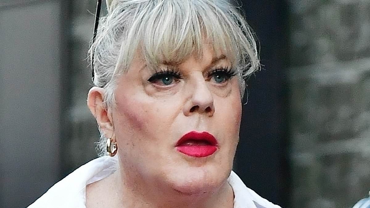 Suzy Eddie Izzard, 63, dresses for the heatwave in a bright pink miniskirt and a white blouse as she heads out for a stroll in Soho