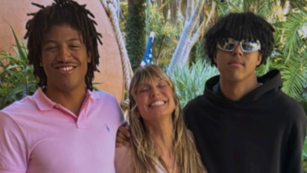 Heidi Klum is dwarfed by sons Henry, 19, and Johan, 18, as they join her for a rare photo - after admitting she 'loves working with her kids' following eldest boy's catwalk debut in Paris