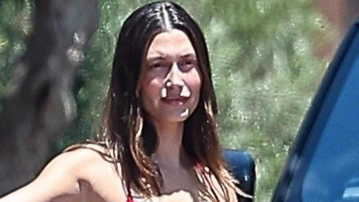 Hailey Bieber flashes her toned midriff in a red tank top and low-rise jeans as she steps out after Justin's four-word message