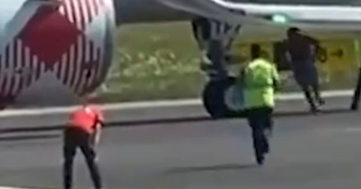 Chilling moment man ran past airport staff before throwing himself into engine