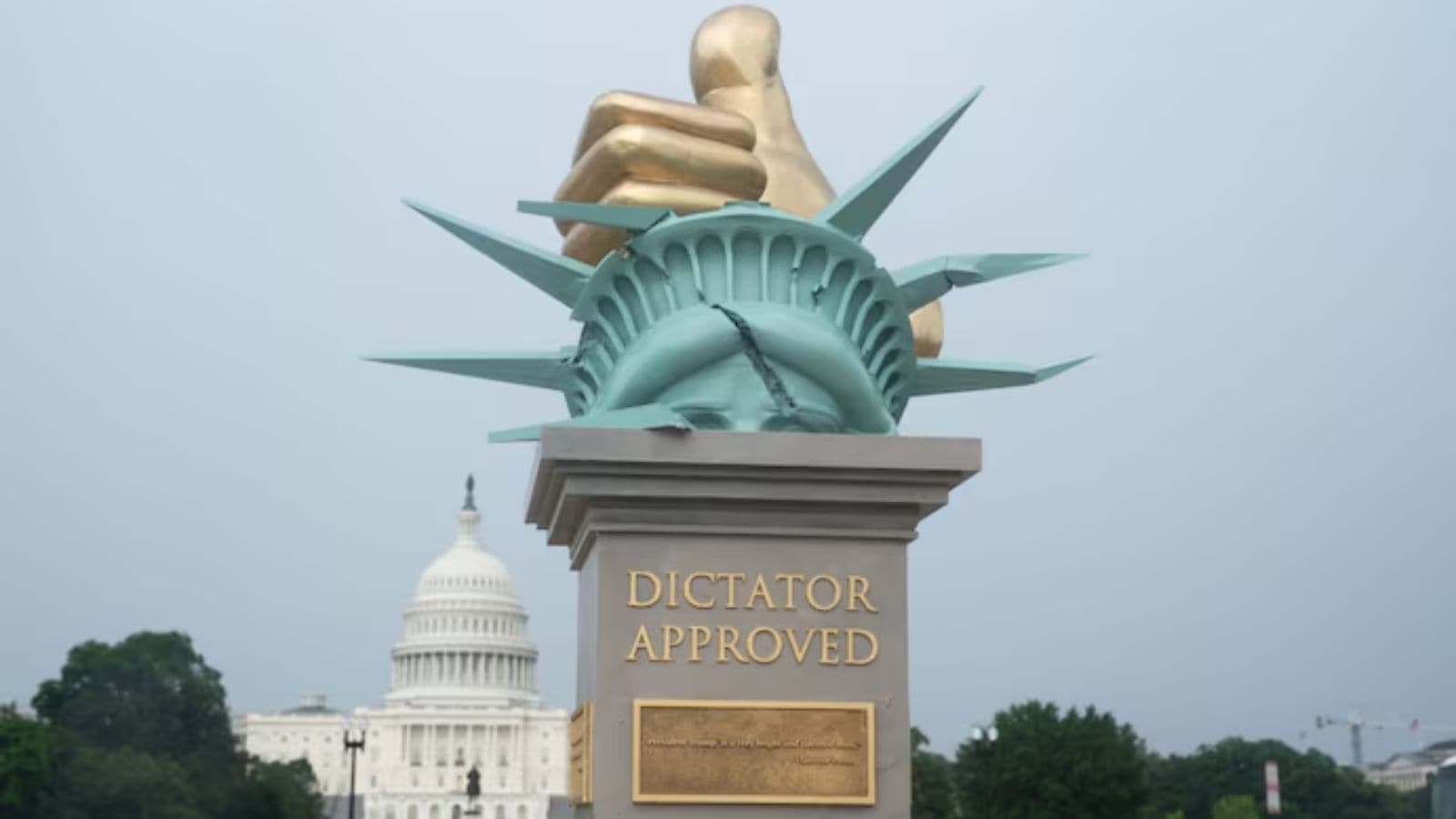 ‘Dictator Approved': a golden thumbs-up crushing Statue of Liberty sculpture appears on National Mall