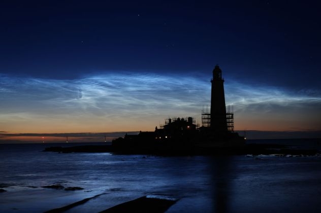 Noctilucent clouds shimmer in summer sky, with a possible boost from rockets