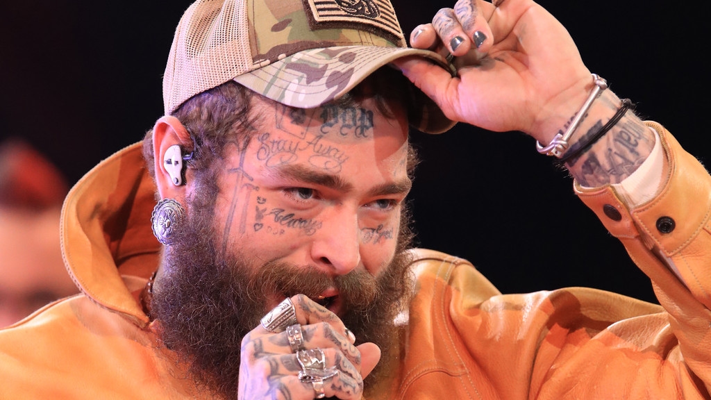 Post Malone tumbles off stage while attempting to toast fan