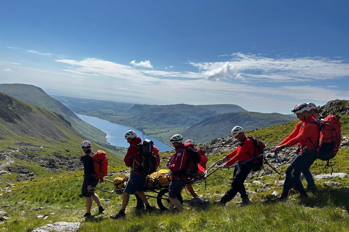 Mountain rescue team help injured walker on Scafell Pike in Lake District