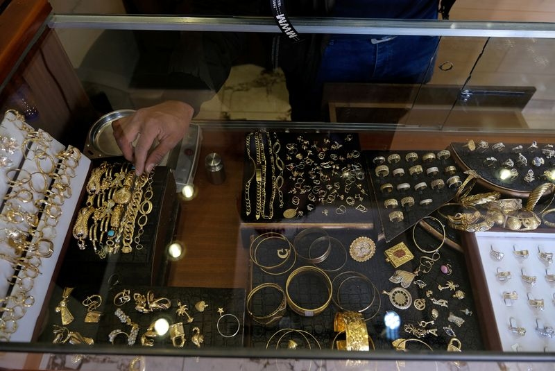 Gold hovers near one-week low as firmer US dollar, yields weigh