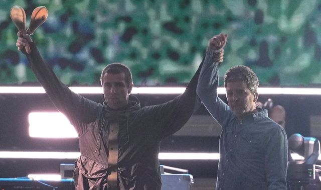Gallagher brothers share a high-five and hug as Oasis reunite on stage after 16 years