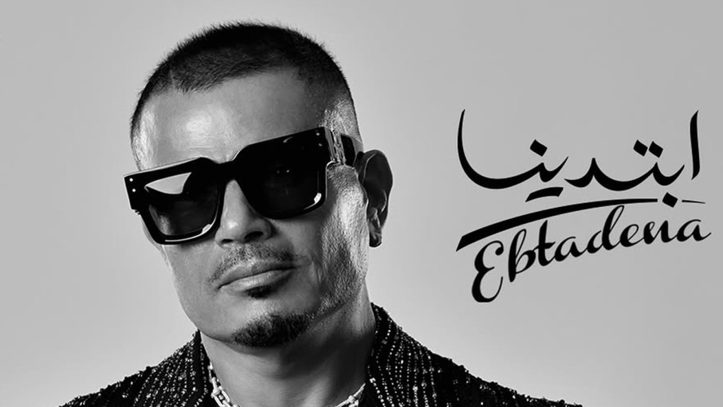 مجوهرات فاخرة وسترة مرصعة بكريستالات.. تفاصيل إطلالة عمرو دياب على بوستر الألبوم الجديد